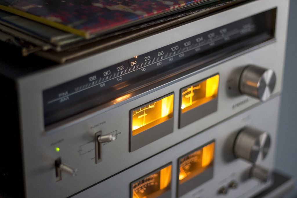 Close up of silver coloured radio, Radio is turned on with illuminated  warm lights 