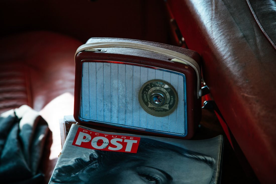 Brown and silver coloured vintage Radio on top of a Picture Post magazine
